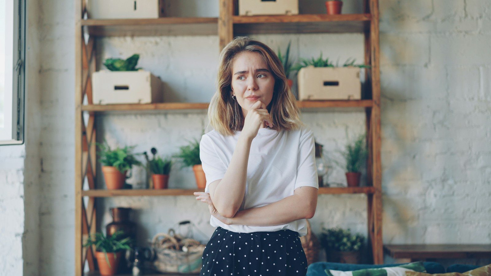 A young woman with hand on chin looking thoughtful